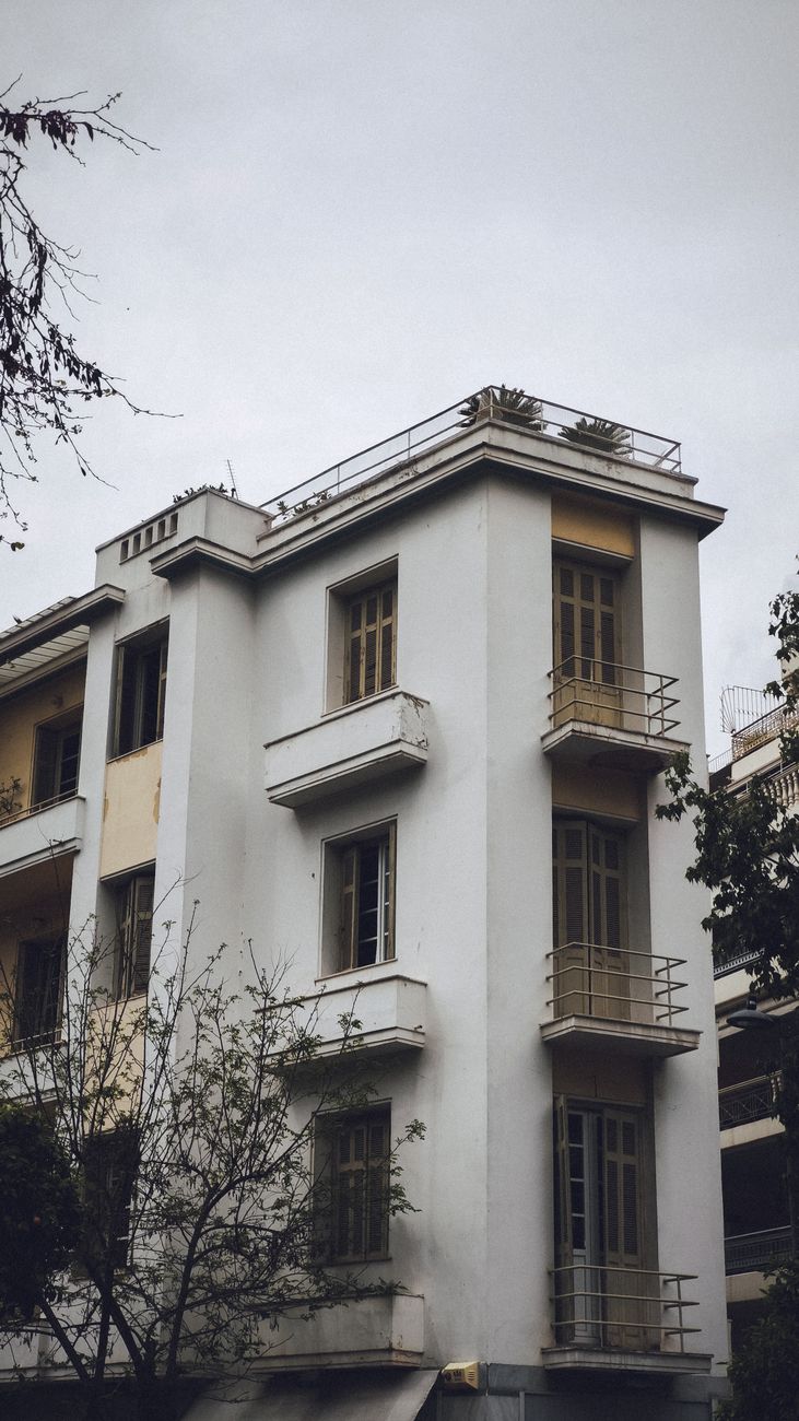 Fachada de um prédio de quatro andares com sacadas que avançam para fora da linha da parede