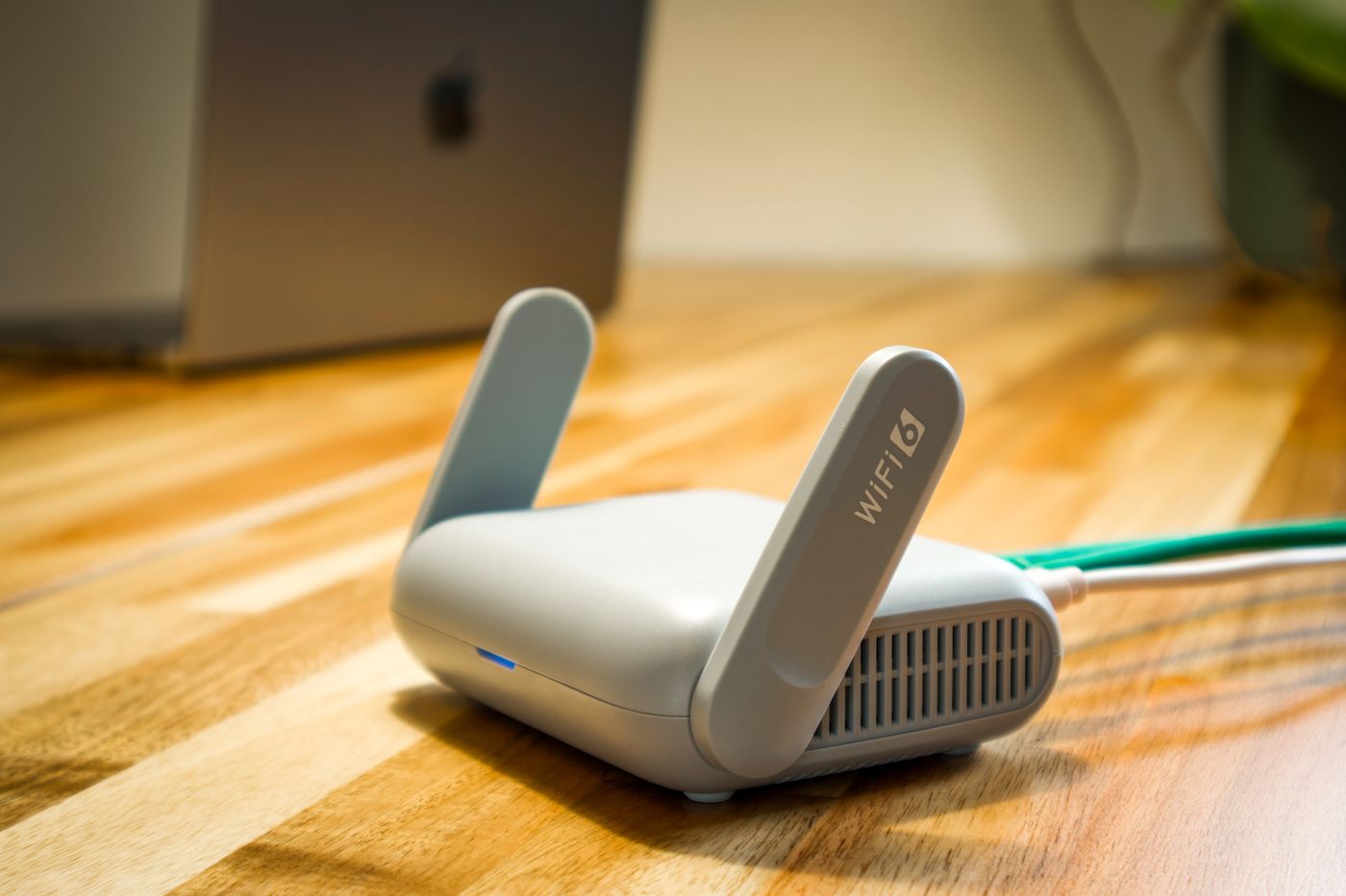 roteador de internet branco com antenas levantadas e cabo de rede conectado