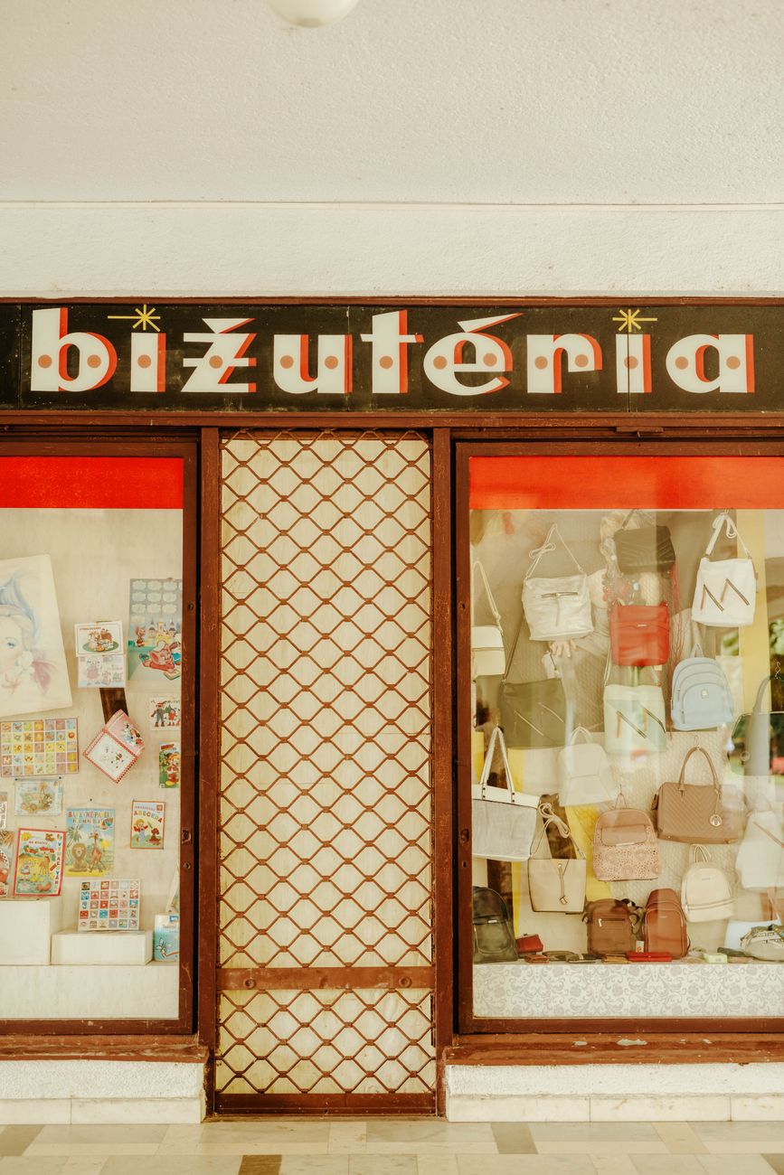 Fachada de uma loja de rua com vitrine de bolsas e a porta de entrada ao centro