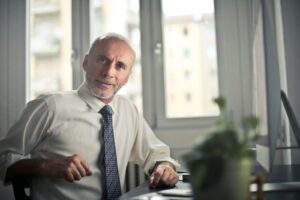 Homem de terno sentado à mesa do próprio escritório