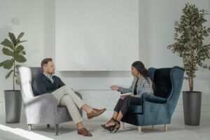 Sala de atendimento com duas poltronas de frente uma para a outra e plantas ao fundo