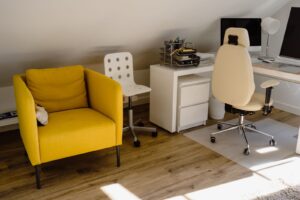Mesa de trabalho em casa com cadeira de escritório e computador junto à janela