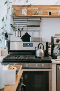 Fogão a gás com forno numa cozinha de casa, visto de frente