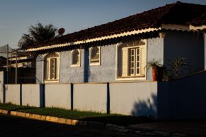 Casa brasileira de telhado de barro vista da rua, com o muro na frente