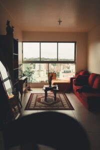 Sala de estar de apartamento brasileiro com janela grande e vista da cidade