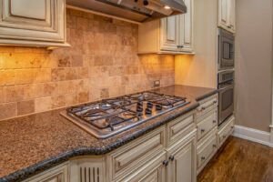 Cooktop a gás embutido na bancada de granito de uma cozinha