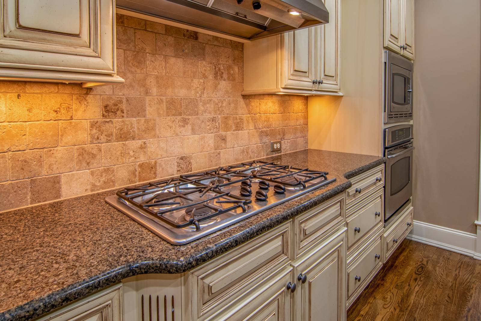 Cooktop a gás embutido na bancada de granito de uma cozinha