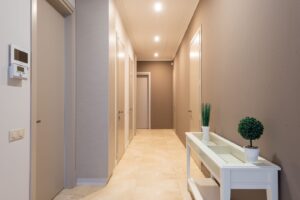 Corredor de apartamento com várias portas fechadas de um lado e do outro
