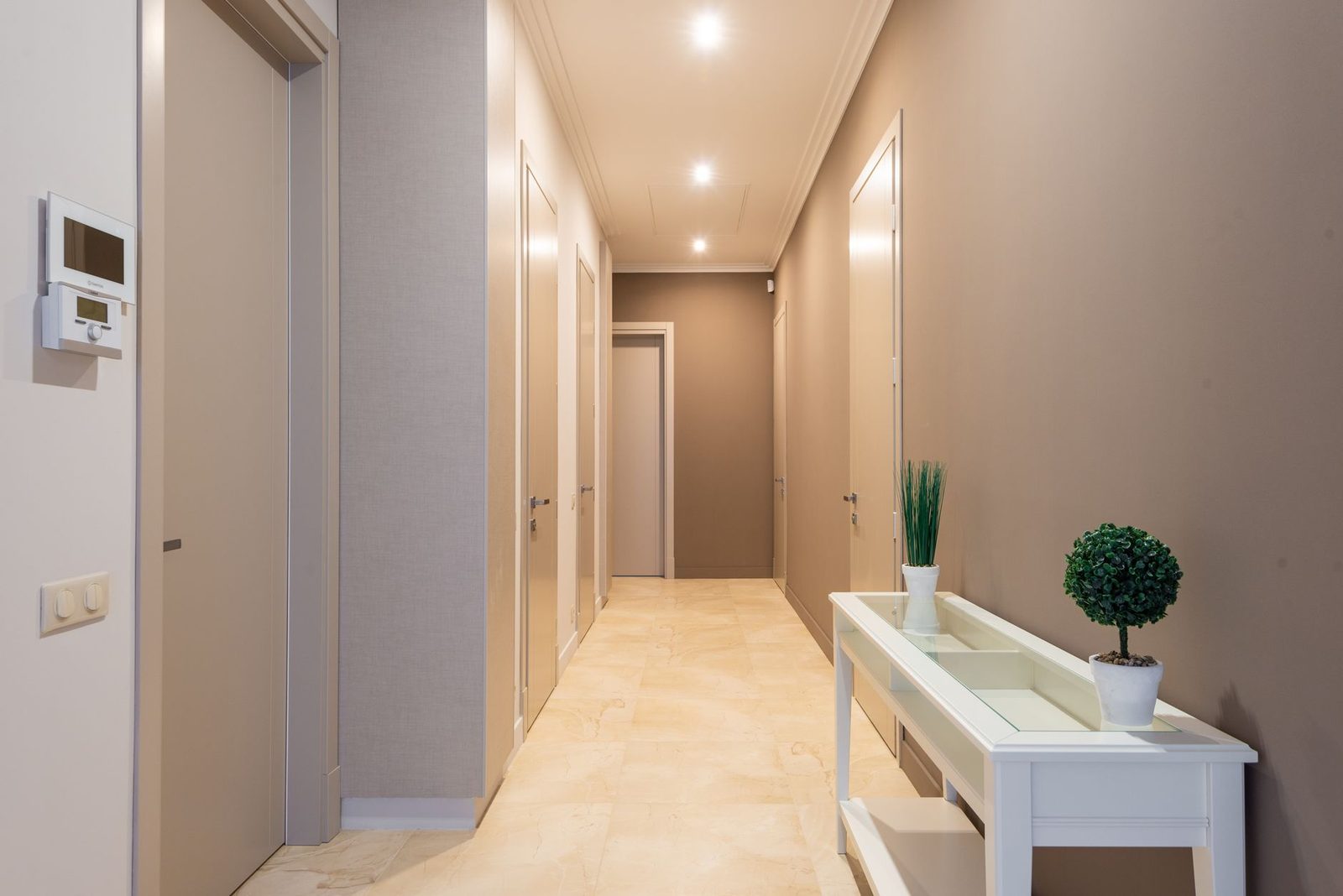 Corredor de apartamento com várias portas fechadas de um lado e do outro