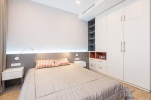 Quarto de casal com parede firme atrás da cama, cabeceira e uma mesa de cabeceira de cada lado