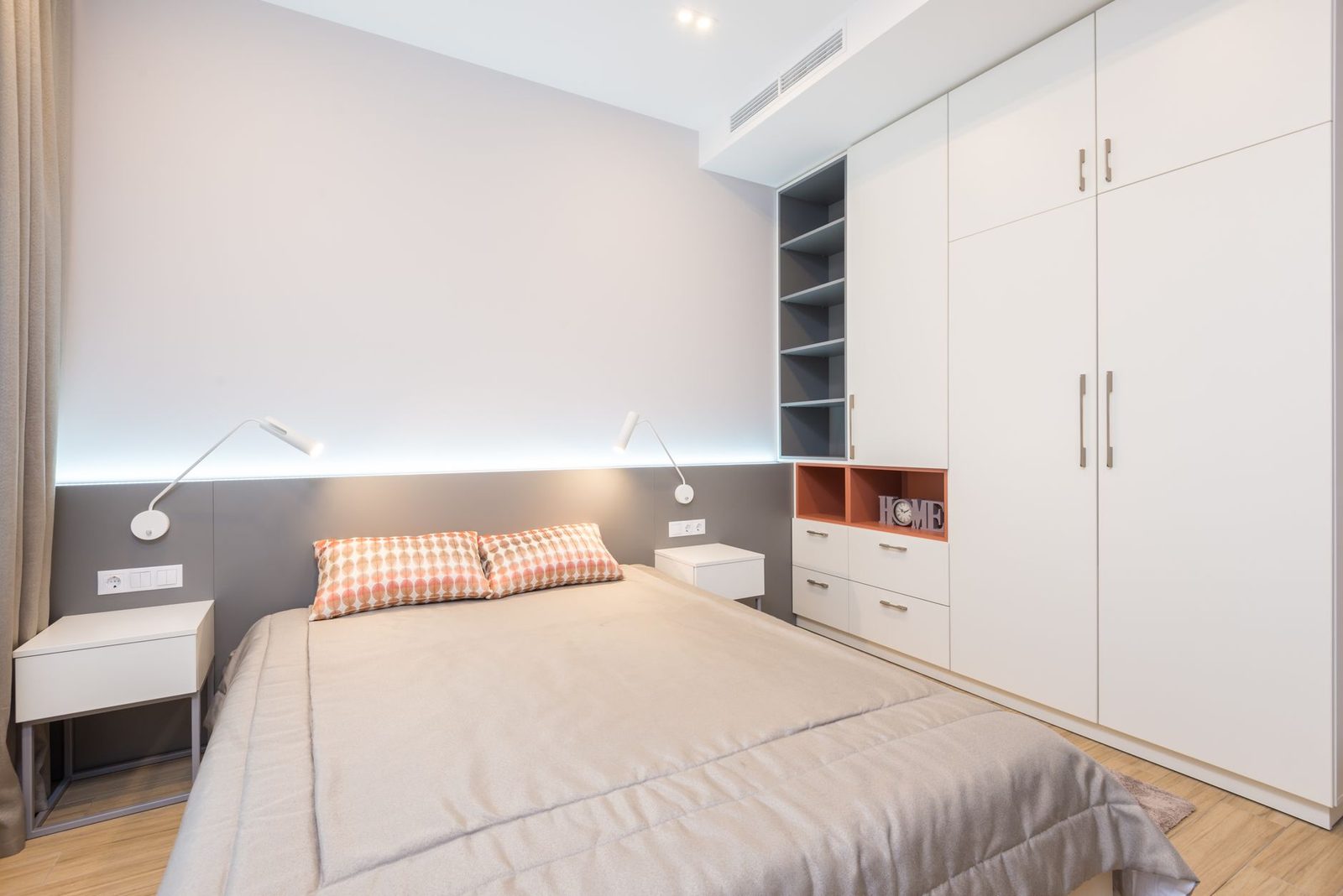 Quarto de casal com parede firme atrás da cama, cabeceira e uma mesa de cabeceira de cada lado
