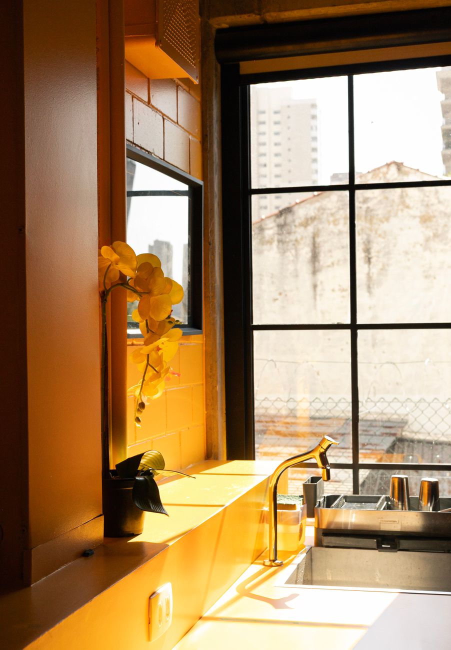 Cozinha de apartamento com a pia junto à janela e a vista da cidade